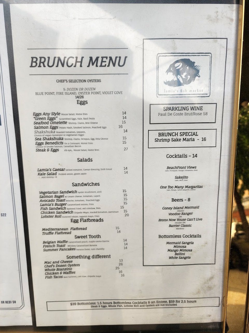 Printed menu beside a plate of fresh fish.